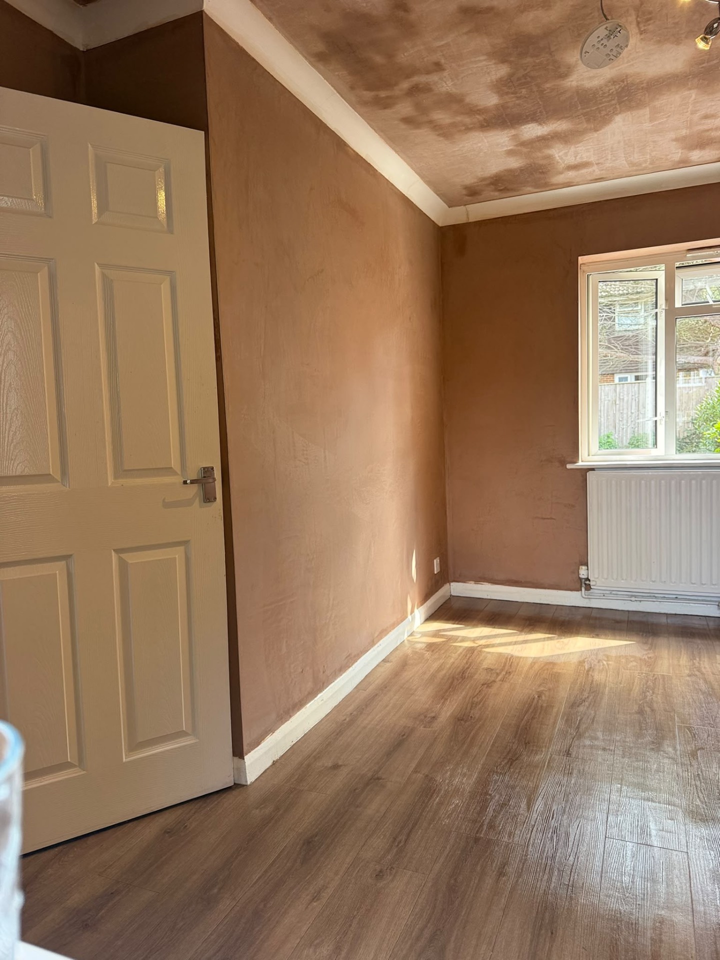 Freshly plastered bedroom walls and ceiling beside a white panel door